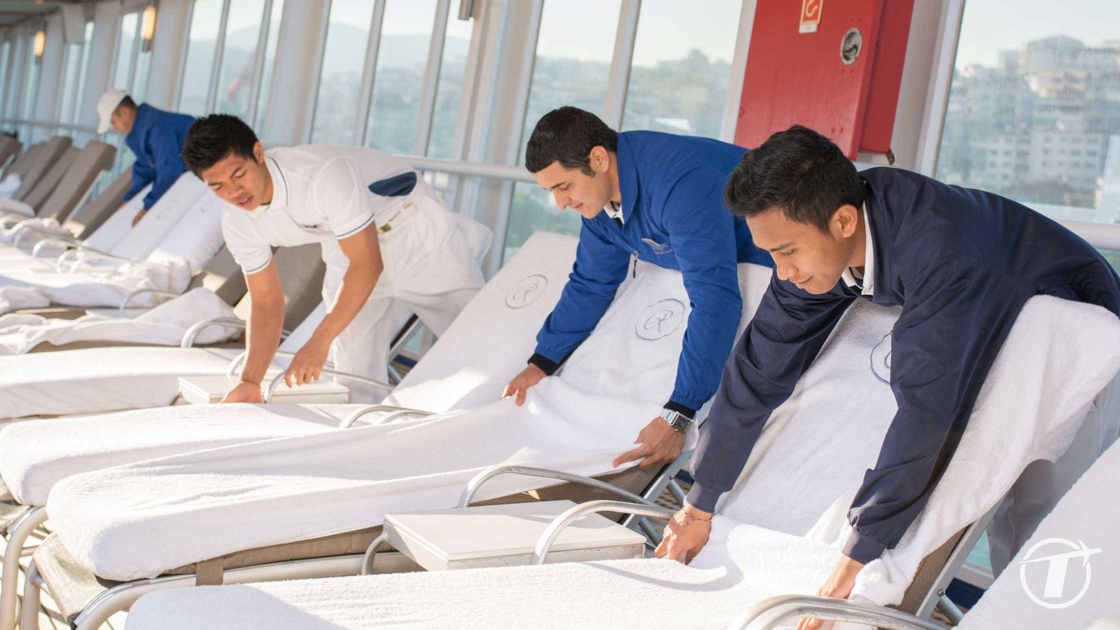 Crew preparing deck chairs on luxury cruise